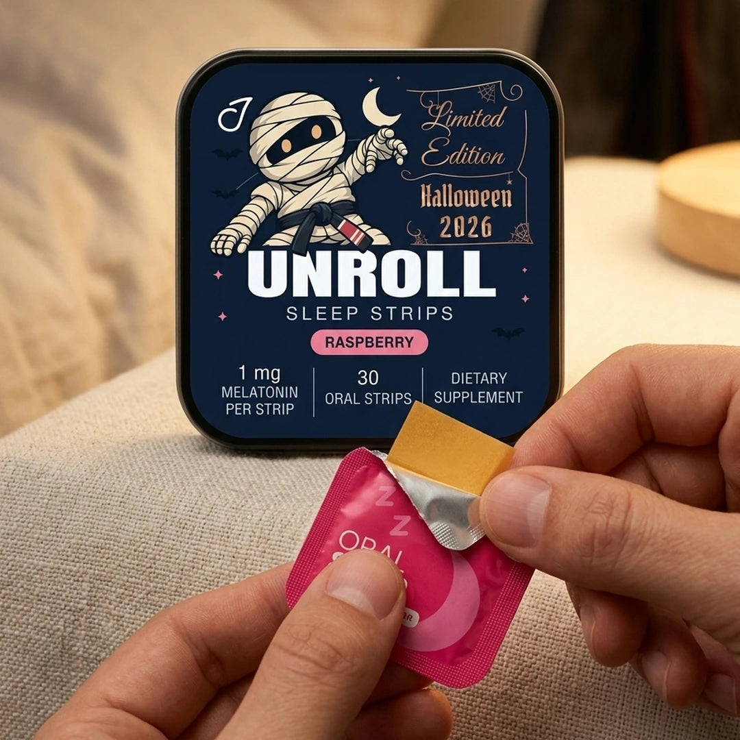 Hands peeling open a raspberry oral strip beside the Halloween 2026 Unroll tin
