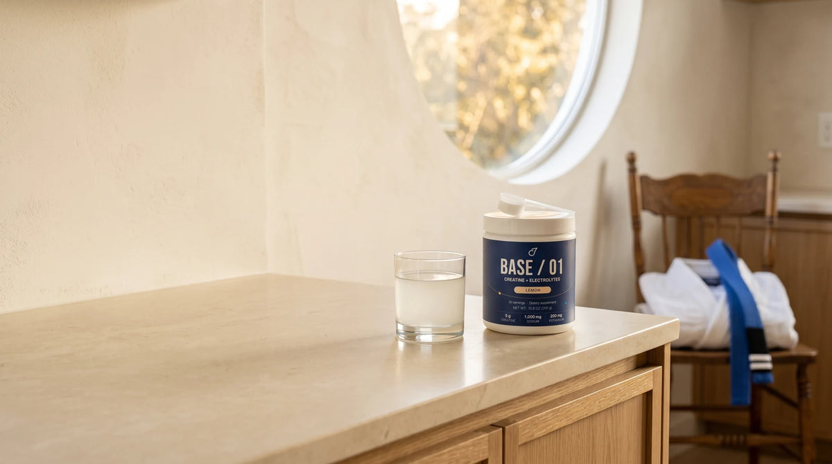 Base / 01 and lemon water in a sunlit kitchen with a gi and blue jiujitsu belt
