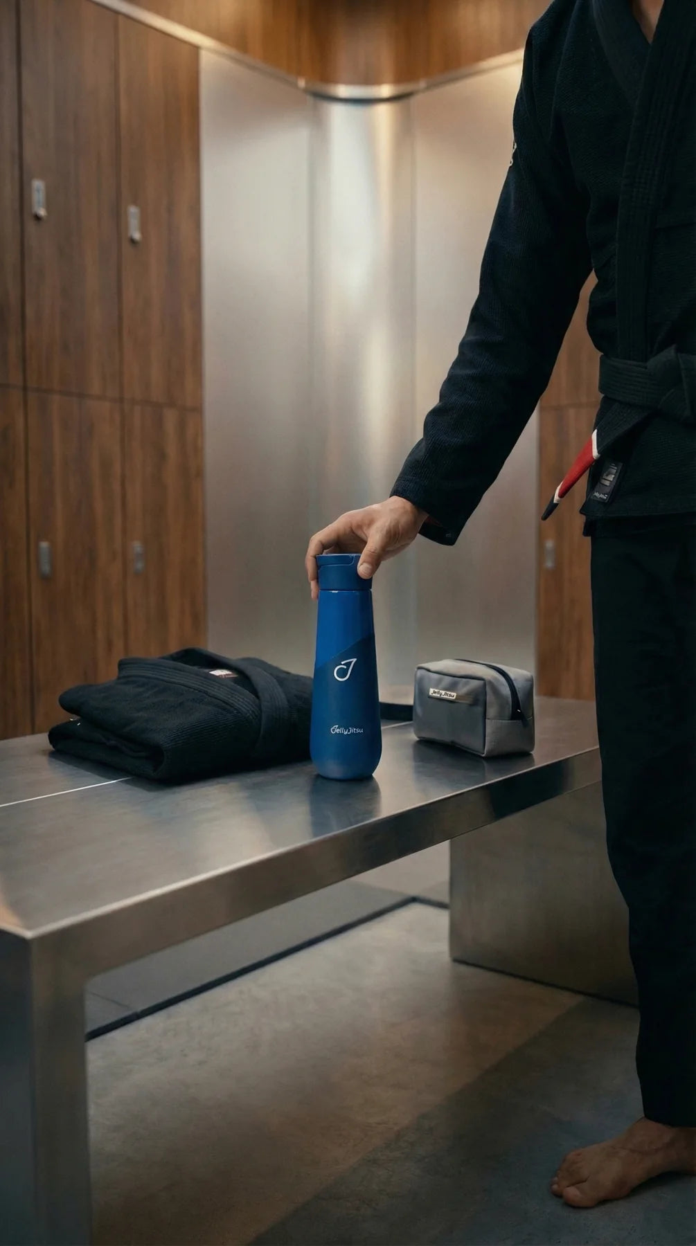 Black belt jiujitsu athlete packing the blue bottle beside a folded gi