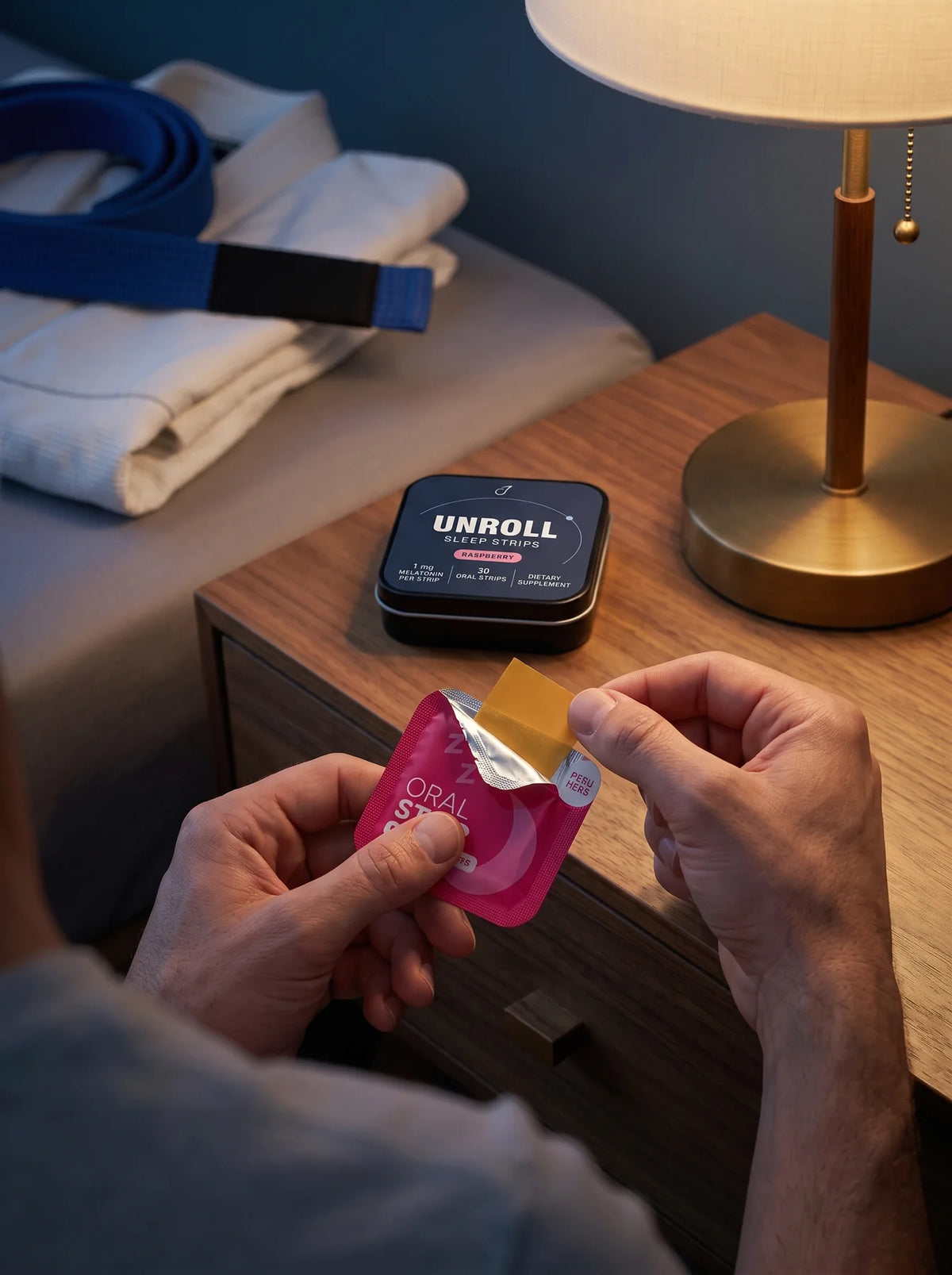Hands opening a raspberry packet to reveal an amber oral strip
